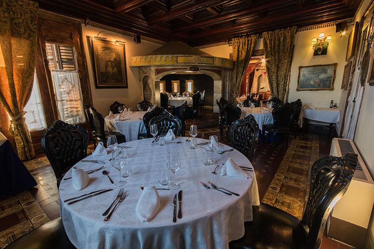 Comedor del palacio con techo de madera y mesas vestidas